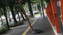 Kondisi tiang yang miring di Jalan Gedung Kesenian, Jakarta, Jumat (22/2). Keberadaan tiang miring tersebut membahayakan keselamatan pejalan kaki karena kabel yang turut menjuntai hingga ke bawah. (Liputan6.com/Immanuel Antonius)