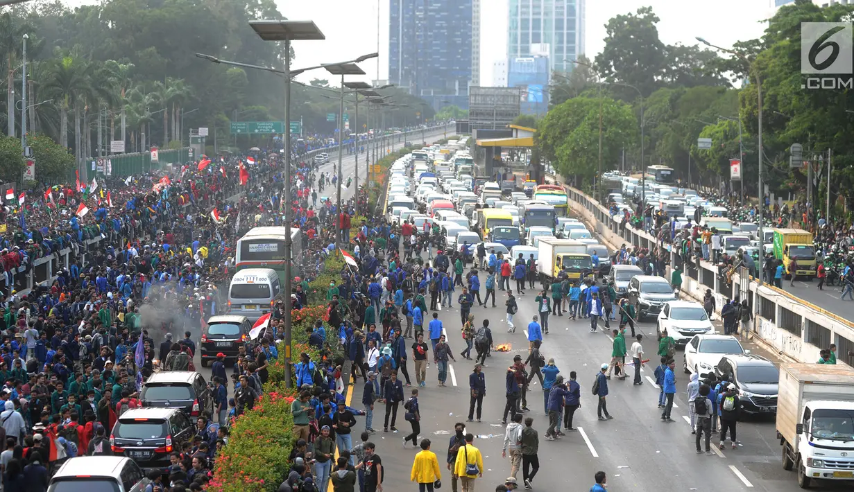 Mahasiswa memblokade Tol Dalam Kota saat berdemonstrasi menolak RUU KUHP dan revisi UU KPK di depan Gedung DPR, Jakarta, Selasa (24/9/2019). Demonstrasi mahasiswa membuat arus lalu lintas Tol Dalam Kota lumpuh. (merdeka.com/Arie Basuki)