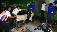 Petugas PT KA Daop 2 Bandung menaikkan sepeda motor ke gerbong kereta program angkutan motor gratis mudik Lebaran 2018, Bandung, Selasa, 22 Mei 2018. (Liputan6.com/Arie Nugraha)