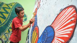 Warga membatik tulis di sebuah dinding di Kampung Batik di Palbatu, Jakarta, Jumat (2/10). Kegiatan dalam rangka memperingati Hari Batik Nasional ini untuk memupuk rasa cinta akan batik sebagai warisan budaya asli Indonesia. (Liputan6.com/Gempur M Surya)