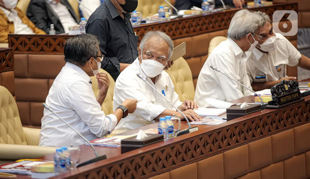 Menteri Pekerjaan Umum dan Perumahan Rakyat (PUPR) Basuki Hadimuljono (kedua kiri) berbincang saat mengikuti rapat kerja bersama Komisi V DPR RI di Kompleks Parlemen, Senayan, Jakarta, Selasa (17/1/2023). Rapat tersebut membahas tentang pembahasan program-program Kementerian PUPR tahun 2023 dan evaluasi pelaksanaan anggaran tahun 2022. (Liputan6.com/Faizal Fanani)