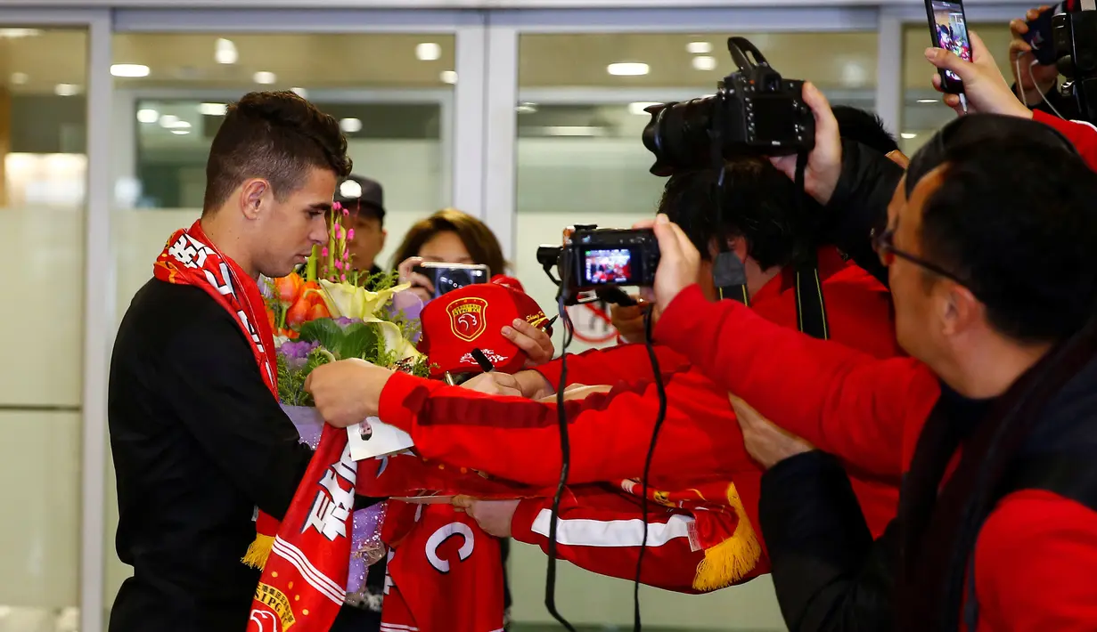 Gelandang asal Brasil, Oscar memberikan tanda tangan kepada para penggemar yang menyambut kedatangannya di Bandara Internasional Shanghai Pudong di Shanghai, Senin (2/1). Oscar akhirnya setuju bergabung bersama klub China Shanghai SIPG. (REUTERS/Aly Song)