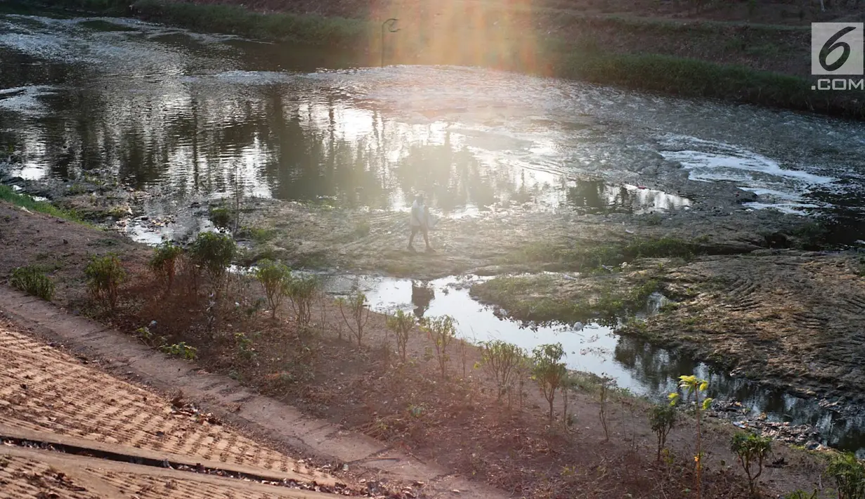 Warga beraktivitas di sekitar aliran Kanal Banjir Timur yang mengalami kekeringan, kawasan Duren Sawit, Jakarta, Selasa (3/9/2019). Kemarau panjang yang melanda Ibu Kota menyebabkan debit air Kanal Banjir Timur berkurang hingga menampakkan dasar kanal. (Liputan6.com/Immanuel Antonius)