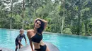 Bikini hitam halterneck dengan model ring di bagian perut juga memerlihatkan body goalsnya.  (@indahkalalo)