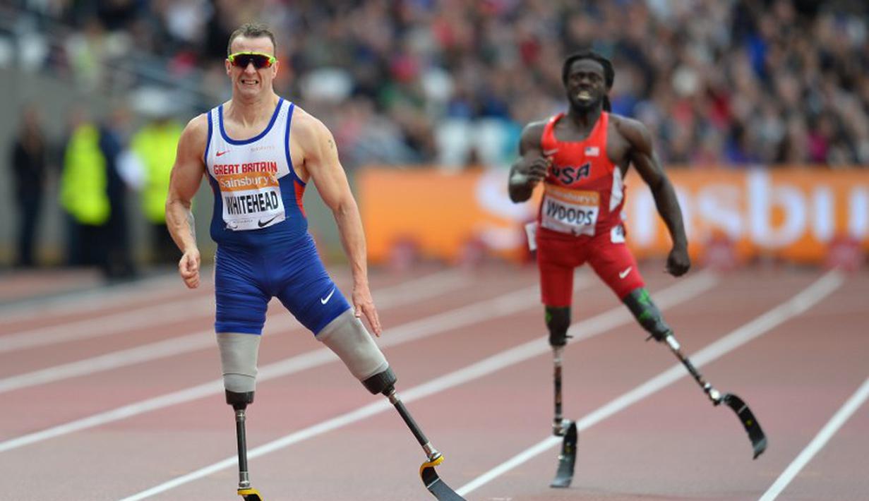 Pelari Inggris, Richard Whitehead (kiri) memenangi lari 200m T42 putra paralympic games di Stadion Queen Elizabeth Olympic Park di Stratford, Inggris, (26/7/2015). (AFP PHOTO/Glyn Kirk)
