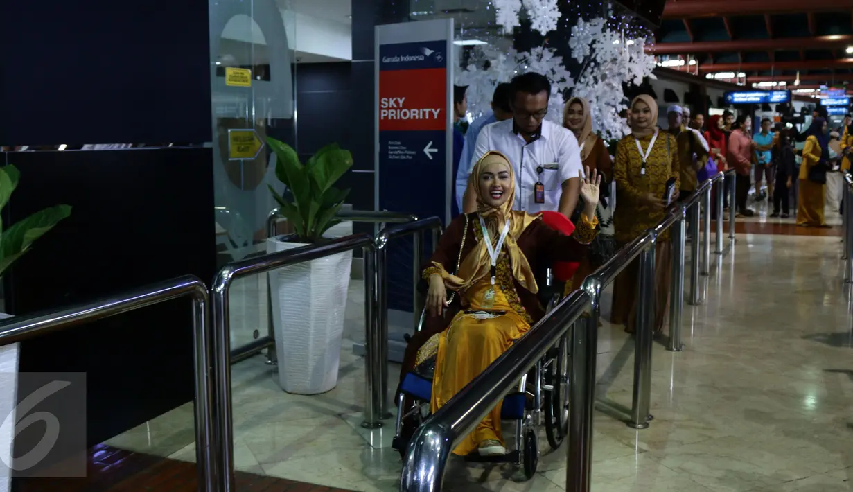 Julia Perez (Jupe) menggunakan kursi roda untuk menuju ruang tunggu keberangkatan di Bandara Seokarno Hatta, Tangerang, Senin (2/1). Menderita kanker serviks stadium 4 tak menyurutkan niat Jupe beribadah umrah ke Tanah Suci. (Liputan6.com/Herman Zakharia)