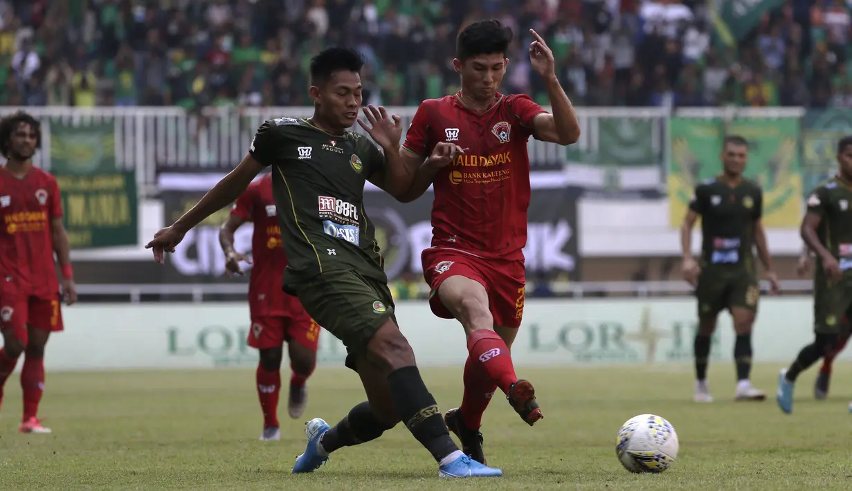 Bek Tira Persikabo, Vava Mario, berebut bola dengan gelandang Kalteng Putra, Fajar Handika, pada laga Shopee Liga 1 di Stadion Pakansari, Bogor, Jumat (26/7). Tira Persikabo menang 5-2 atas Kalteng. (Bola.com/Yoppy Renato)
