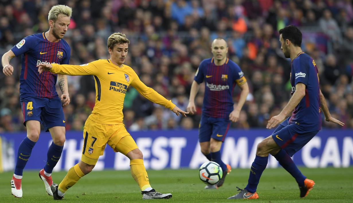 Striker Atletico Madrid, Antoine Griezmann, berusaha melewati kepungan pemain Barcelona pada laga La Liga Spanyol di Stadion Camp Nou, Barcelona, Minggu (4/3/2018). Barcelona menang 1-0 atas Atletico. (AFP/Lluis Gene)