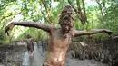 Seorang remaja berpose dengan badan penuh lumpur saat mengikuti Mebuug-buugan di desa Kedonganan, Bali (18/3). Mebuug-buugan ini diadakan sehari setelah Nyepi, bertujuan untuk menetralisir sifat-sifat buruk. (AFP/Sony Tumbelaka)