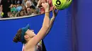 Petenis asal Swiss Belinda Bencic memberikan tanda tangan setelah kemenangannya melawan Viktoriya Tomova dari Bulgaria selama pertandingan tunggal putri mereka pada hari kedua Australia Terbuka di Melbourne, Selasa (17/1/2023). Selain bola-bola, foto dan halaman tertentu majalah tenis menjadi barang favorit yang disodorkan fans ke petenis favoritnya. (WILLIAM WEST / AFP)