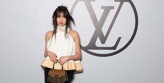 Hyein NewJeans hadir pertama kali di Paris Fashion Week sebagai BA Louis Vuitton. Mengenakan halter ruffle top dan celana panjang, penampilannya terlihat playful dengan clutch dan boots LV [Louis Vuitton]