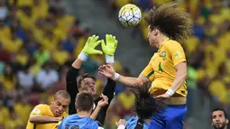 Bek Brasil, David Luiz, duel dengan kiper Uruguay, Fernando Muslera, pada kualifikasi Piala Dunia 2018 di Recife, Brasil, Sabtu (26/3/2016) pagi WIB. Hasil seri ini  membuat Brasil berada di posisi ketiga Zona CONMEBOL. (AFP/Vanderlei Almeida)