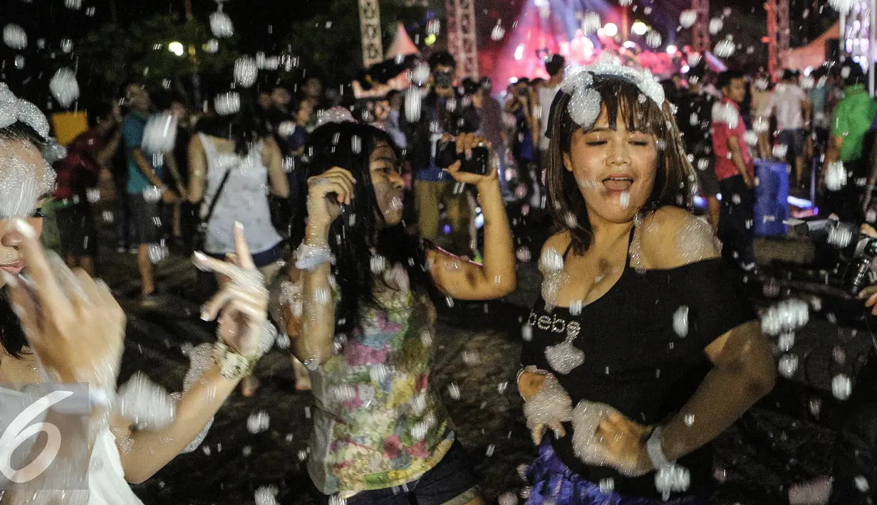 Para wanita menari sambil menikmati alunan musik yang di mainkan DJ saat acara Foam Party di Pantai Festival Ancol, Jakarta, Minggu (2/8/2015). Event musik dengan nuansa busa tersebut diramaikan dengan aksi para DJ ternama. Liputan6.com/Faizal Fanani)