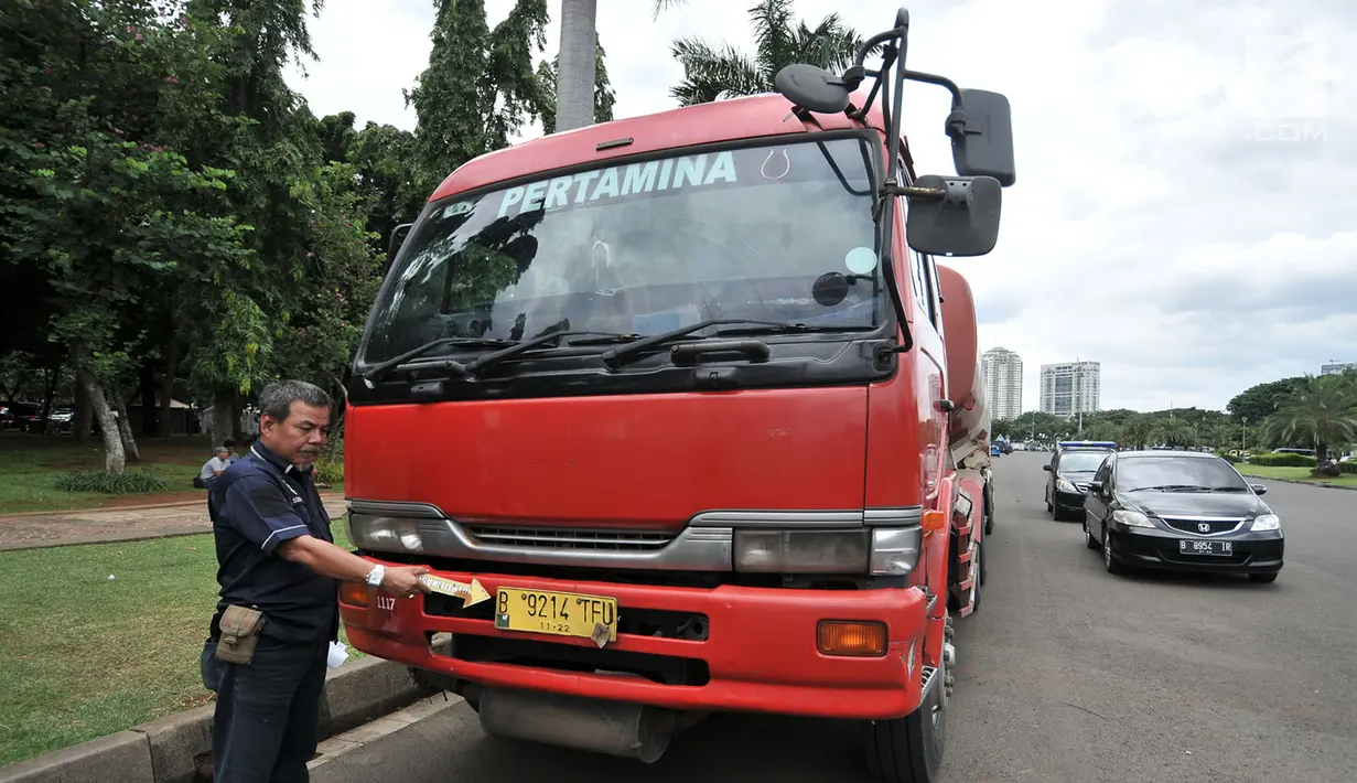 Petugas kepolisian melakukan identifikasi truk tangki Pertamina di Lapangan Monas, Jakarta, Senin (18/3). Sebelumnya, pada pagi tadi truk tangki berpelat polisi B 9214 TFU dan B 9575 UU tersebut dibajak oleh pendemo. (merdeka.com/Iqbal S. Nugroho)