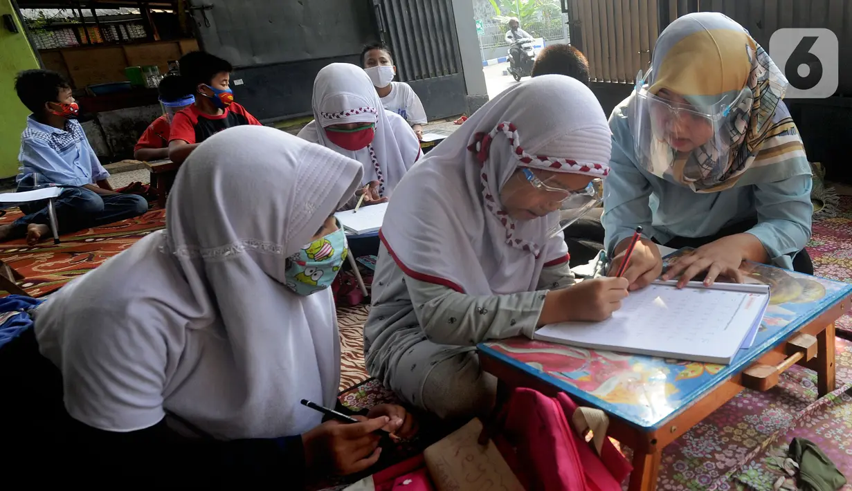 Murid kelas IV SD Muhammadiyah 37 belajar di teras rumah seorang guru di kawasan Pondok Cabe Udik, Tangerang Selatan, Banten, Senin (10/8/2020). Kegiatan belajar mengajar (KBM) tatap muka ini dilakukan dengan menerapkan standar protokol kesehatan. (merdeka.com/Arie Basuki)