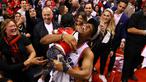 Pebasket Toronto Raptors, Kyle Lowry, menggendong putranya usai mengalahkan Milwaukee Bucks pada NBA Final Wilayah Timur di Scotiabank Arena, Toronto, Sabtu (25/5). Raptors menang 4-2 atas Bucks. (AFP/Gregory Shamus)