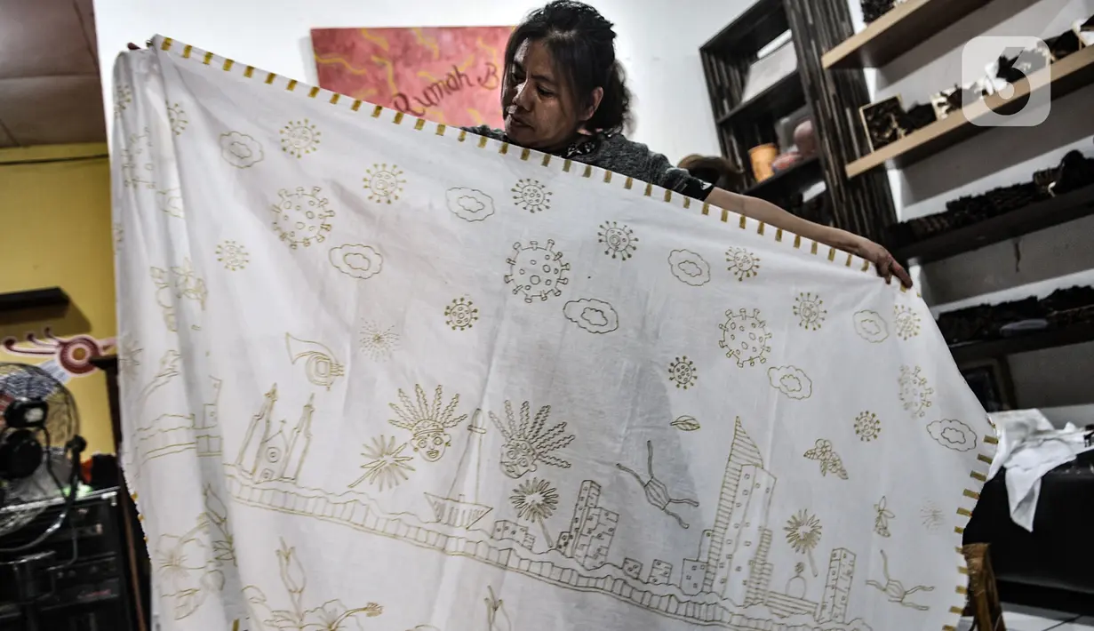 Perajin menyelesaikan pembuatan batik bermotif Covid-19 di Rumah Batik Palbatu, Jakarta, Kamis (15/10/2020). Sempat tutup akibat pandemi, Rumah Batik Palbatu perlahan bangkit dengan menciptakan kain batik edisi Jakarta Terkini bergambar Covid-19 dipadu ikon-ikon Ibu Kota. (merdeka.com/Iqbal Nugroho)