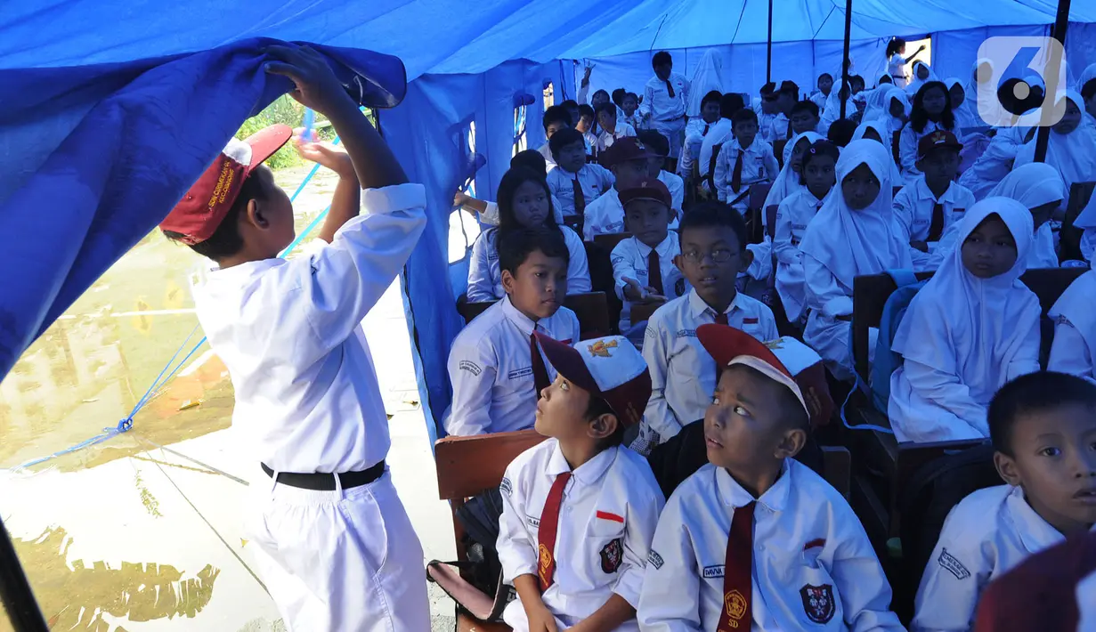 Murid-murid berada di dalam tenda darurat  akibat bangunan atau kelas roboh saat hujan deras  pada hari Rabu (1/1/2020) lalu di SDN Cirimekar 2, Cibinong, Bogor, Senin (6/1/2020). (merdeka.com/Arie Basuki)