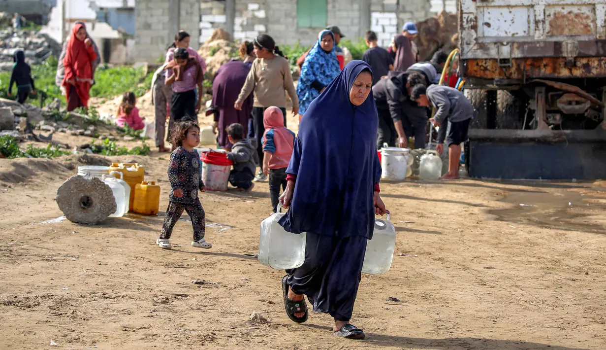 Hingga Februari 2026, krisis air bersih di Gaza telah mencapai titik yang sangat kritis, dengan ketersediaan air yang anjlok drastis akibat kerusakan masif pada infrastruktur vital. Tampak dalam foto, warga mengisi wadah air dari tangki air portabel di kamp pengungsi Palestina Maghazi, Jalur Gaza tengah pada Rabu 11 Februari 2026. (Eyad BABA/AFP)