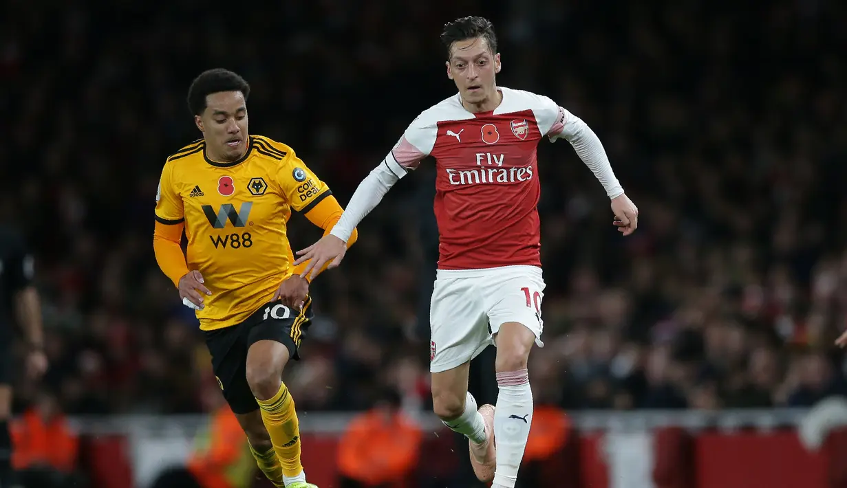 Aksi Mesut Ozil saat mengiring bola kontra Wolverhampton pada laga lanjutan Premier League, yang berlangsung Minggu (11/11) di stadion Emirates. Arsenal ditahan imbang Wolverhampton 1-1. (AFP/Daniel Olivas)
