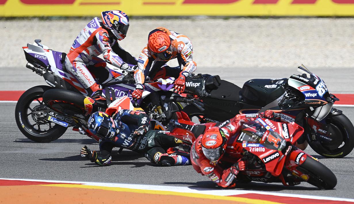 Pebalap Repsol Honda, Marc Marquez (tengah atas) terjatuh setelah menabrak pebalap CryptoData Aprilia, Miguel Oliveira (tengah bawah) pada balapan MotoGP Portugal 2023 di Sirkuit Internasional Algarve, Portimao, Portugal, Minggu (26/3/2023). (AFP/Patricia De Melo Moreira)