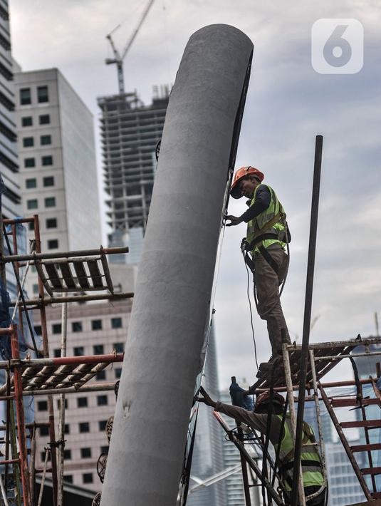 Pekerja saat menyelesaikan pembangunan Tugu Sepeda di Jalan Jenderal Sudirman, Jakarta, Senin (5/4/2021). Pembangunan tugu ini berbentuk satu buah ban sepeda berukuran raksasa. (merdeka.com/Iqbal S. Nugroho)