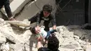 Relawan memberikan bayi kepada temannya setelah serangan udara di kota Suriah bagian utara, Aleppo, Kamis (28/4). Penyelamatan bayi berlangsung dramatis melalui tangga yang nyaris ambruk usai serangan udara. (AFP PHOTO / Ameer ALHALBI)