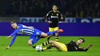 Pemain Borussia Dortmund, Julian Weigl dan pemain Hertha Berlin Ondrej Duda terjatuh saat berebut bola pada lanjutan Bundesliga di Olympiastadion Berlin, Sabtu (20/1). Hasil imbang 1-1 mengakhiri duel antara Hertha Berlin vs Dortmund. (Tobias SCHWARZ/AFP)