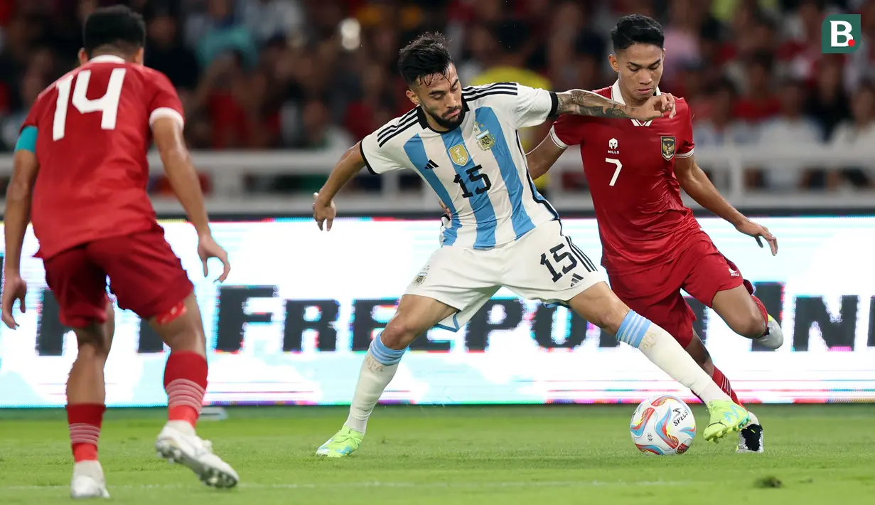 Pemain Timnas Indonesia, Marselino Ferdinan (kanan) berebut bola dengan pemain Argentina, Nicolas Gonzalez pada laga FIFA Matchday di Stadion Utama Gelora Bung Karno (SUGBK), Senayan, Jakarta, Senin (19/06/2023). (Bola.com/Bagaskara Lazuardi)