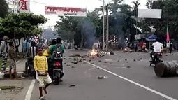 Massa turun ke jalan dalam unjuk rasa yang berujung kerusuhan di Manokwari, Papua, Senin (19/8/2019). Mereka membakar gedung DPR juga memblokade jalan dengan membakar ban sebagai buntut dari peristiwa yang dialami mahasiswa Papua di Surabaya dan Malang, serta Semarang beberapa hari lalu. (STR / AFP)