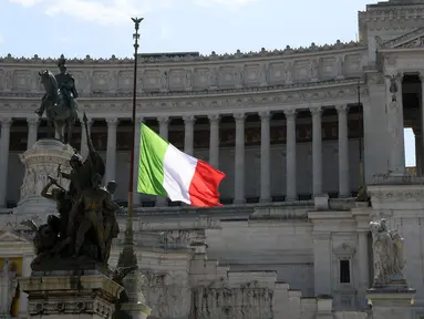 Bendera nasional Italia dikibarkan setengah tiang sebagai tanda berkabung atas korban meninggal akibat pandemi COVID-19 di Palazzo Chigi, Roma, 31 Maret 2020. Italia mengheningkan cipta dan menaikkan bendera setengah tiang atas kematian 11.591 orang akibat virus corona.  (Xinhua/Alberto Lingria)