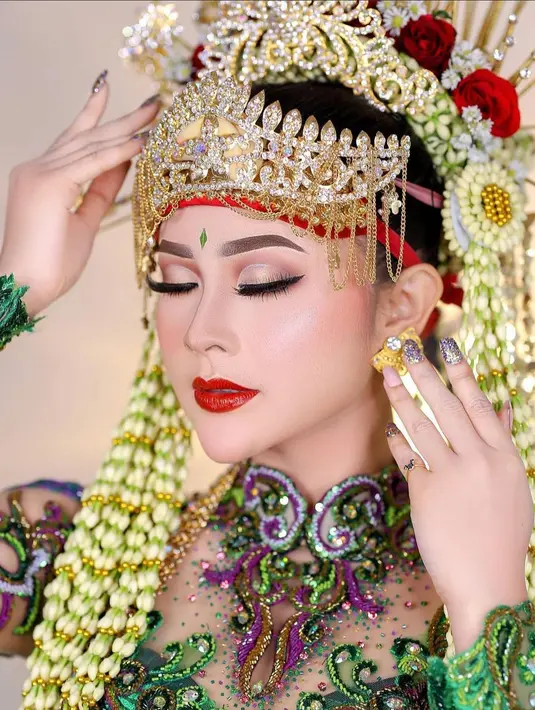 Satu lagi Bella Bonita menghadirkan makeup pengantin yang bold bernuansa merah merona. Lengkap dengan hair piece bak pengantin dan kembang melati, serta berbagai aksesori emas yang serasi dengan outfitnya. Foto: Instagram.
