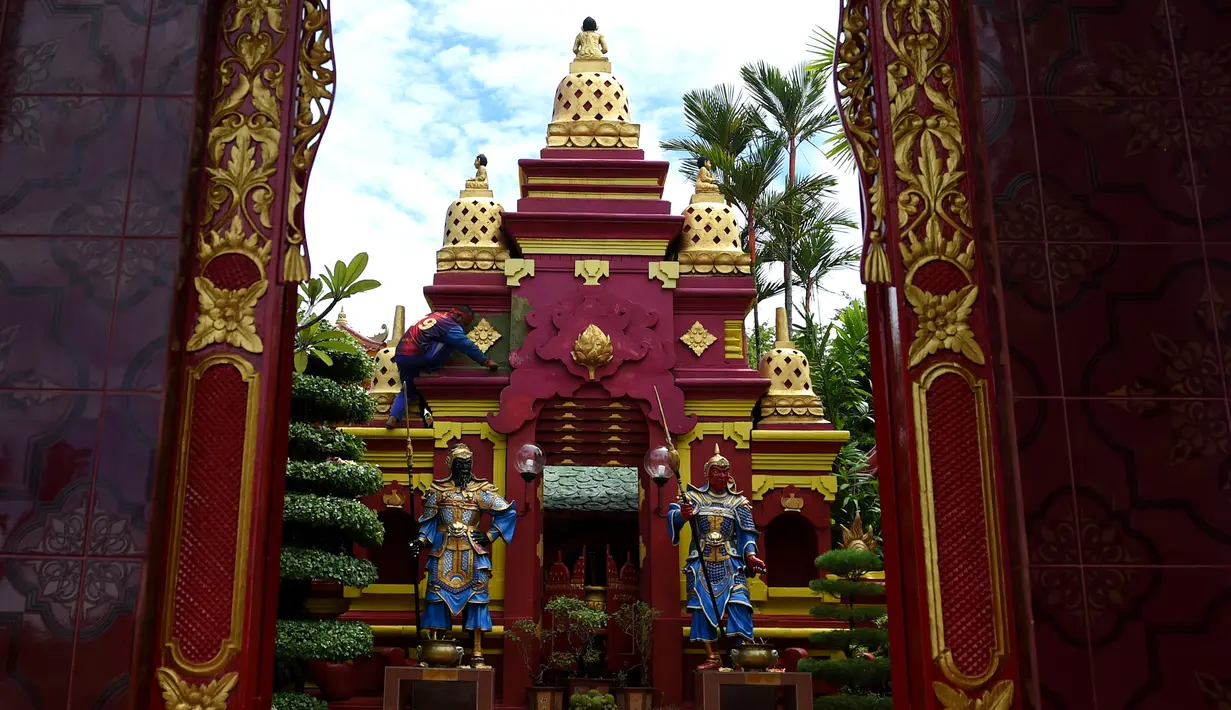 Seorang pekerja mengecat kuil Cina di Denpasar, Bali, Senin (23/1). Pengecatan ini dilakukan dalam rangka menyambut pergantian tahun baru Imlek 2568. (AFP PHOTO / SONNY Tumbelaka)