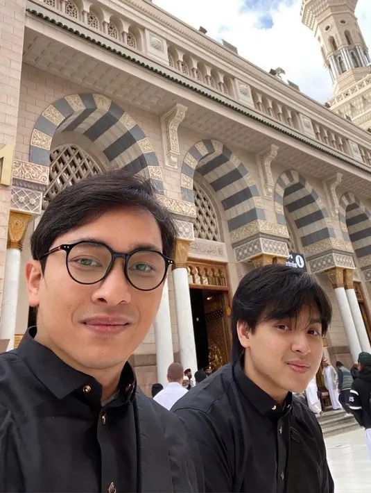 Pelantun lagu 'Bahaya' itu juga memperlihatkan kebersamaan bersama sang ayah sesaat setelah melaksanakan ibadah salat Jumat di Masjid Nabawi. Keduanya kompak memakai baju koko hitam dan tersenyum ke arah kamera. Diketahui, umrah kali ini Yovie Widianto juga bersama rombongan dari label musik miliknya. (Liputan6.com/IG/@arsywidianto)