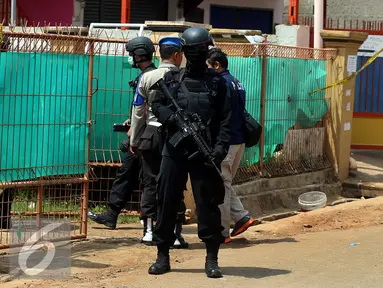 Tim Densus 88 Mabes Polri Indonesia berjaga di rumah terduga anggota jaringan teroris, Bekasi, Minggu (11/12). Densus 88 menangkap tiga orang terduga anggota kelompok teroris dan menemukan bom siap ledak. (Liputan6.com/Johan Tallo)