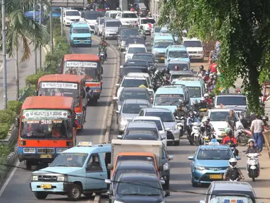 Angkutan umum mencoba menerobos jalur Trans-Jakarta di Jalan Otista Raya, Jakarta, Sabtu (19/11). Rendahnya separator pembatas membuat pengendara dapat leluasa masuk ke jalur tersebut, meskipun berbahaya bagi keselamatan. (Liputan6.com/Immanuel Antonius)