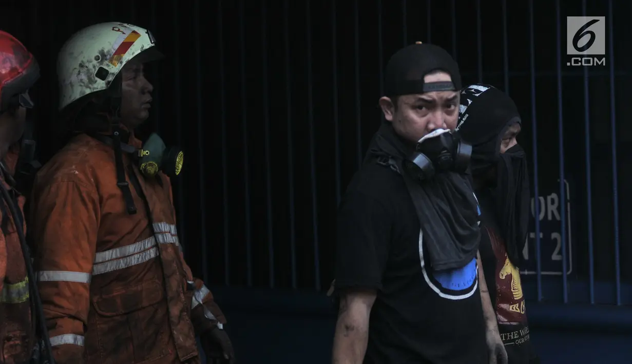 Dua orang korban selamat (kaos hitam) berhasil dievakuasi petugas pemadam dari lokasi kebakaran di Kementerian Perhubungan (Kemenhub), Jakarta, Minggu (8/7). Dalam kebakaran tersebut dilaporkan 3 orang tewas. (Merdeka.com/Iqbal S Nugroho)