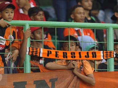 Suporter Persija termangu saat menyaksikan timnya berlaga melawan Madura United FC pada lanjutan Liga 1 di Stadion Patriot Candrabhaga, Bekasi, Kamis (4/5). Persija kalah 0-1. (Liputan6.com/Helmi Fithriansyah)