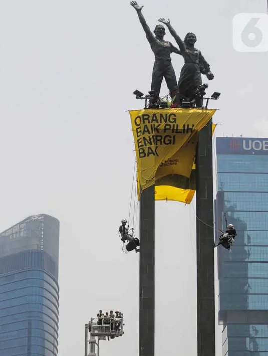 Petugas kepolisian bernegosiasi dengan aktivis lingkungan Green Peace saat membentangkan spanduk di Patung Selamat Datang, Bunderan HI, Jakarta, Rabu (23/10/2019). Dalam aksi yang telah berlangsung selama 13 jam, mereka diamankan petugas yang telah berjaga dibawah. (Liputan6.com/Faizal Fanani)