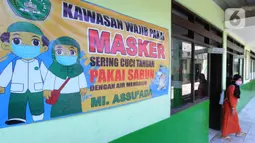 Baliho protokol kesehatan terpasang saat ujian Penilaian Akhir Semester (PAS) tahun pelajaran 2020/2021 di Madrasah Ibtidayah (MI) Assu'ada di Pancoran Mas, Depok, Jawa Barat, Selasa (1/12/2020). Ujian dilaksanakan dengan menerapkan protokol kesehatan dalam kelas. (merdeka.com/Arie Basuki)