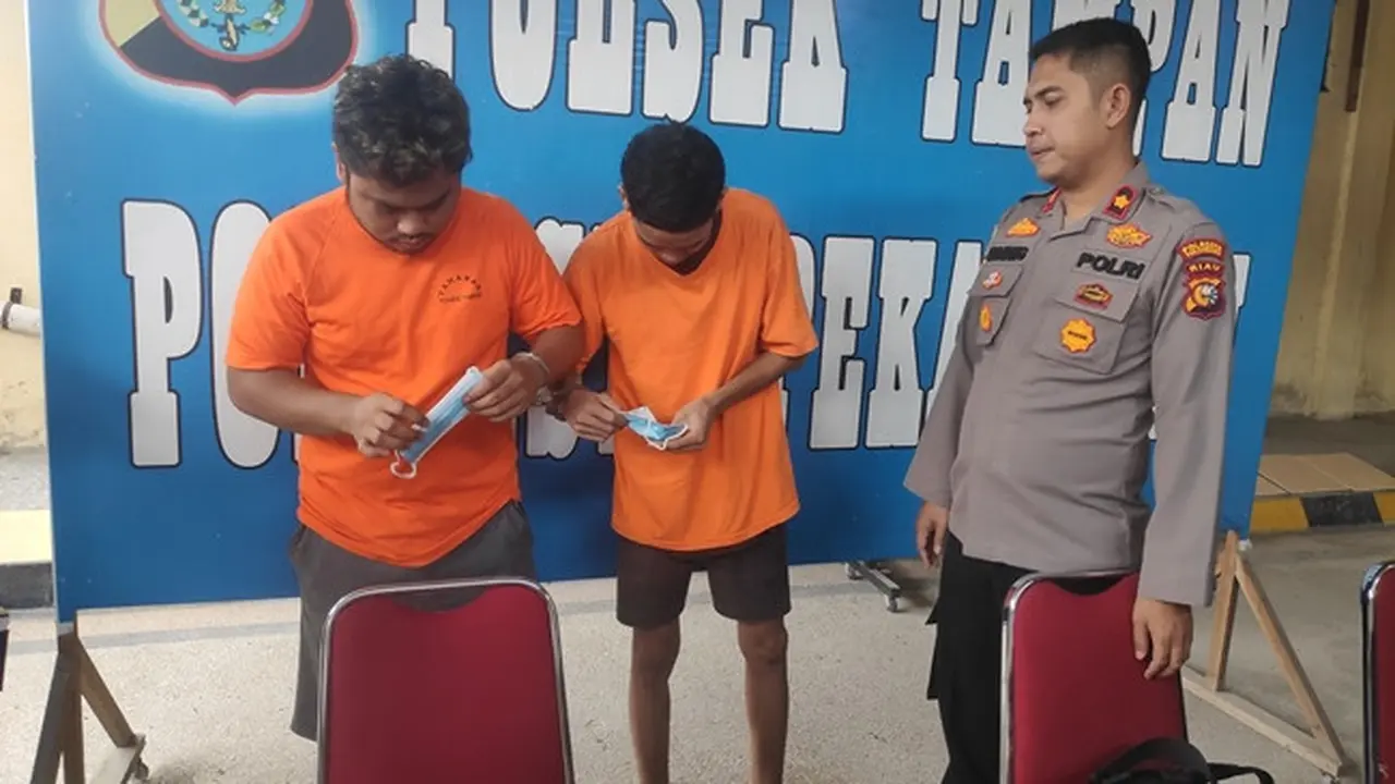 Dua tersangka kepemilikan ribuan pil ekstasi di kantor Polsek Tampan, Pekanbaru.