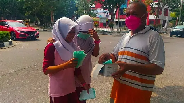 Bagi-bagi masker kepada anak sekolah di Pekanbaru supaya tak terpapar kabut asap.