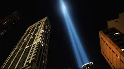 Instalasi cahaya bertajuk 'Tribute in Light'  menembak langit New York City pada Selasa (10/9/2019). Cahaya kembar berwarna biru tersebut dinyalakan untuk memperingati 18 tahun peristiwa serangan gedung kembar World Trade Center (WTC)  pada 11 September 2001 silam. (Spencer Platt/Getty Images/AFP)