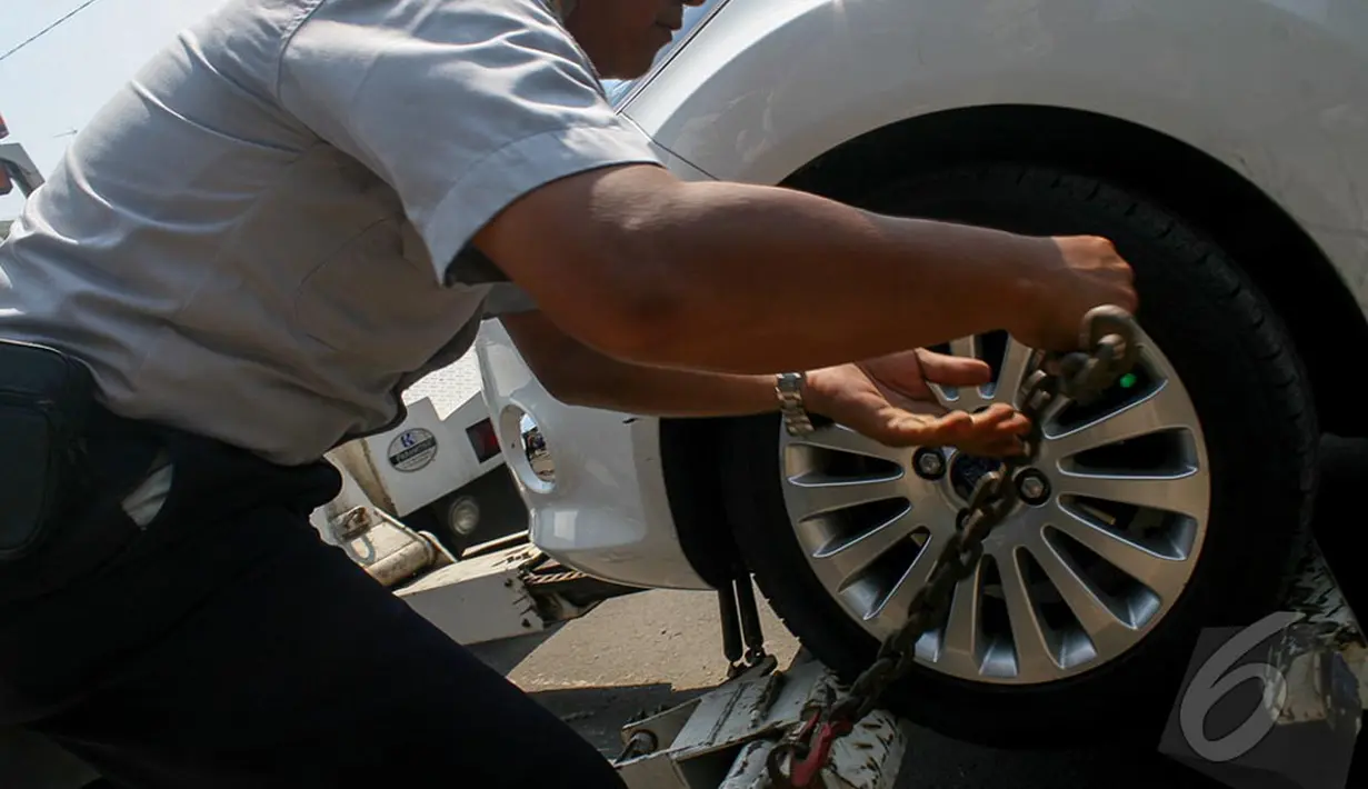 Petugas Dishub sedang menyiapkan alat untuk menderek mobil yang parkir liar, Jakarta, Selasa (23/9/2014) (Liputan6.com/Faizal Fanani)