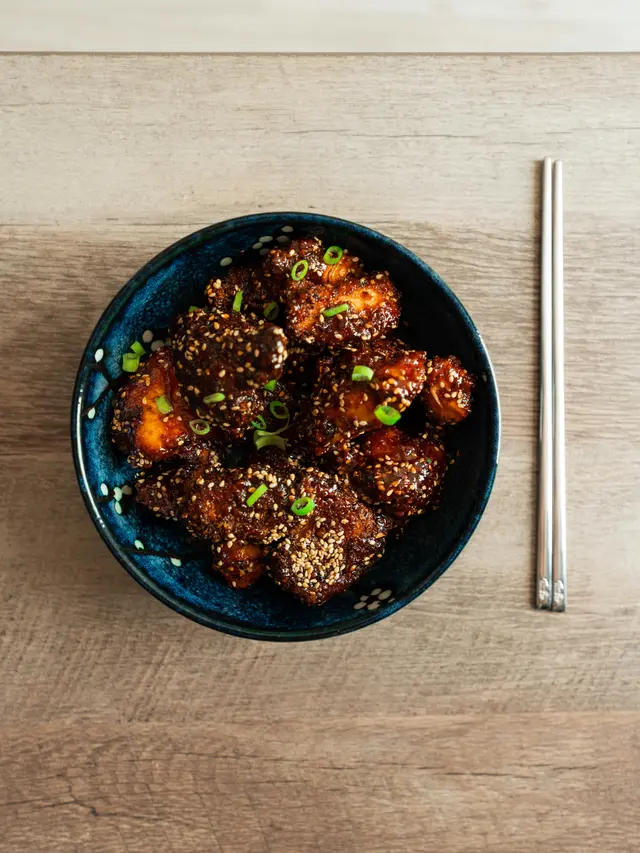 Ilustrasi hidangan Korean fried chicken dengan saus gochujang yang menggugah selera.