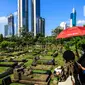 Warga melintas di antara makam di TPU Karet Bivak, Jakarta, Selasa (11/5/2021). Pemprov DKI akan memberlakukan larangan ziarah kubur Idulfitri di seluruh TPU mulai 12 hingga 16 Mei untuk mencegah terjadinya penyebaran Covid-19 saat berkumpul untuk berziarah. (Liputan6.com/JohanTallo)