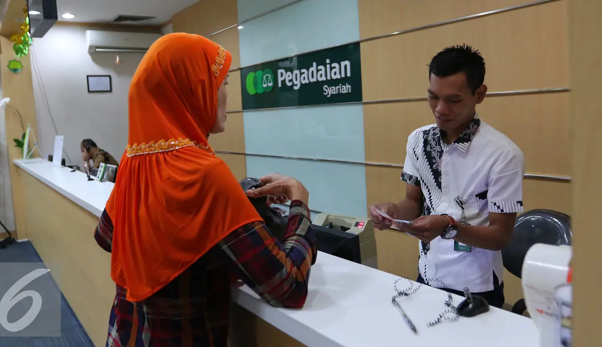 Petugas melayani warga saat transaksi di pegadaian di Jakarta, Rabu (29/6). Transaksi gadai akan  terus alami peningkatan hingga bulan Juli, dimana periode ajaran baru sekolah dan memenuhi kebutuhan hari raya Idul Fitri. (Liputan6.com/Angga Yuniar)