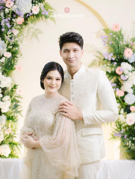 Di acara istimewa tersebut, Yasmine dan Aditya kompak mengenakan busana warna nude ivory yang sesuai dengan dekorasi. Pesona mamah muda yang satu ini juga mencuri perhatian dengan long dress yang dikenakannya. Keduanya terlihat begitu serasi. (Liputan6.com/IG/@jnbphotographyofficial)