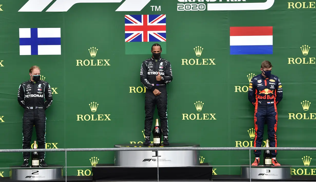 Pembalap Mercedes Lewis Hamilton (tengah) berdiri di podium usai menempati posisi pertama Formula 1 Grand Prix di Spa-Francorchamps, Spa, Belgia, Minggu (30/8/2020). Posisi kedua dan ketiga diisi pembalap Mercedes Valtteri Bottas serta pembalap Red Bull Max Verstappen. (John Thys, Pool via AP)