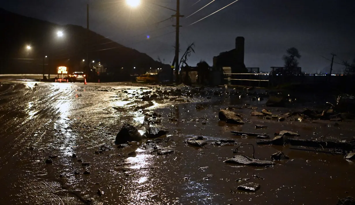 Lumpur dan bebatuan menutupi Pacific Coast Highway, dekat zona Kebakaran Palisades, selama badai di Malibu, California, pada tanggal 13 Februari 2025. (AGUSTIN PAULLIER/AFP)